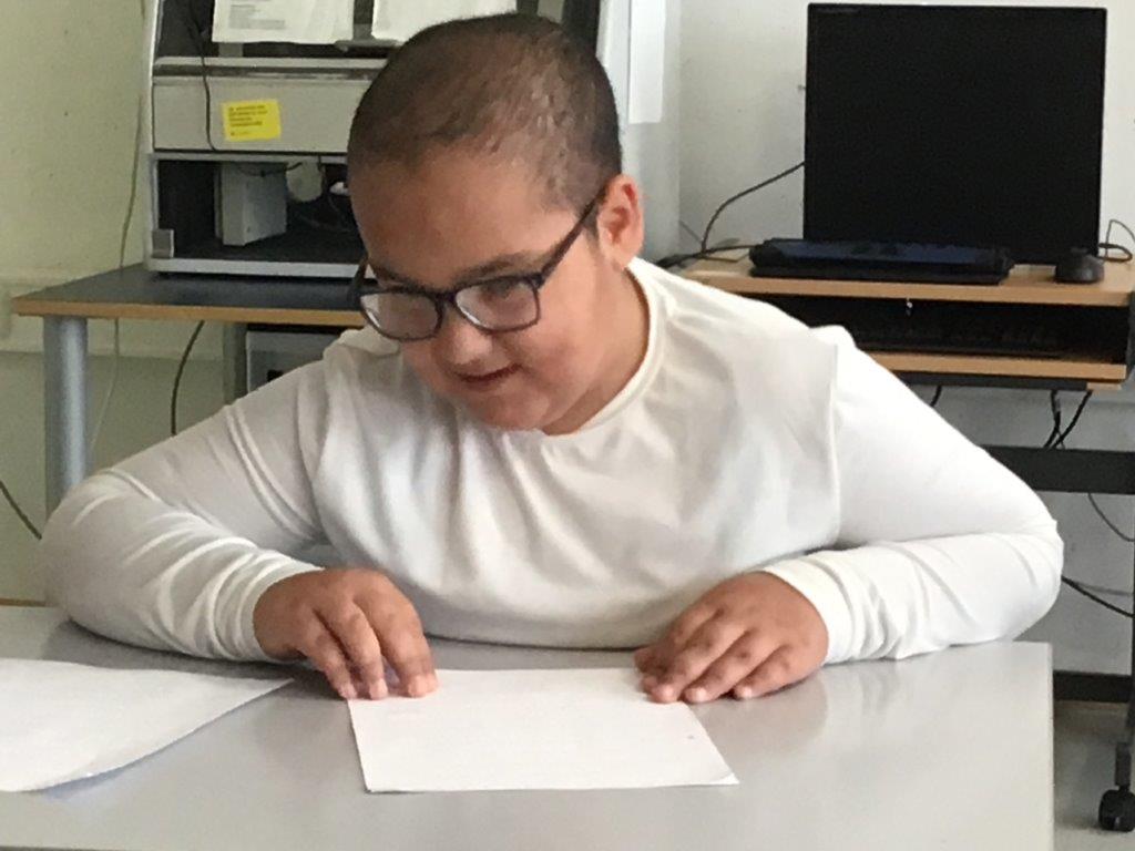Ein Junge liest ein Braille-Buch